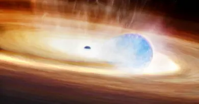 A large glowing disk with a black hole in the center swirls around a small blue orb of light