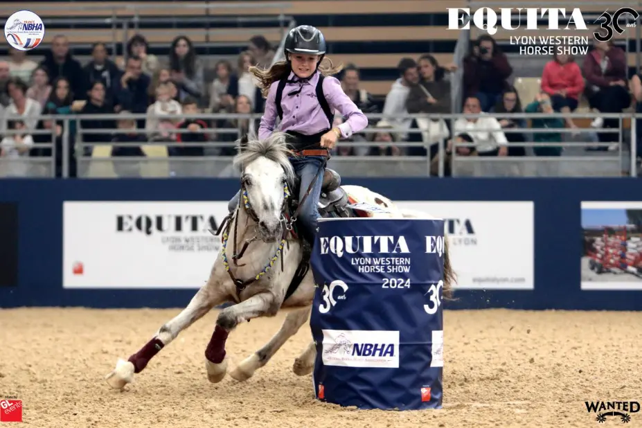La jeune Callie, sur sur la tête, chevauche son poney, pendant une épreuve de barrel racing. Elle est en train de tourner autour d'un tonneau. On sent que ça va vite.