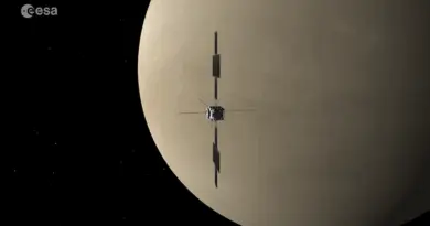 A space probe flies by a tan planet.