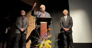 Louis Dallaire, Jacques Matte et Guy Parent sur la scène du Théâtre du Cuivre, Jacques Matte gesticulant derrière le micro.