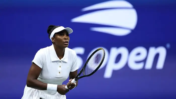 Une joueuse de tennis se prépare à remettre une balle.
