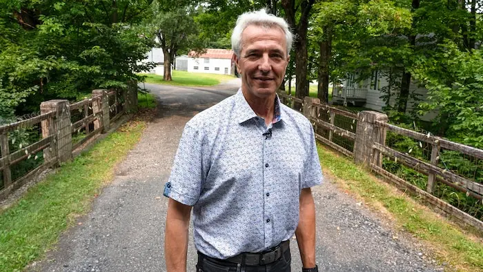 Un homme sur un vieux pont entouré d'arbres.