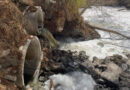 River water is shown rapidly flowing through concrete culverts, creating foam in the Tijuana River. The water appears brownish black because it is contaminated with untreated sewage.