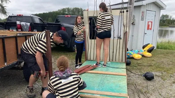 Quatre personnes construisent un bateau de fortune. Elles portent une chandail à l'image de la célèbre famille des Dalton.