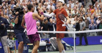 Deux joueurs de tennis se serrent la main au filet. 