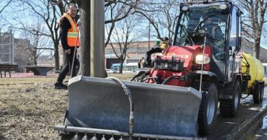 Un tracteur nettoie un trottoir avec des jets d'eau dans l'arrondissement de Ville-Marie, à Montréal.