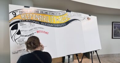 Une personne écrit sur une pancarte où l'on peut notamment lire en anglais : la responsabilité pour la réconciliation.
