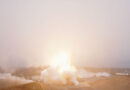 A rocket lifts into a fog layer blanketing its launch site, obscuring the view of the booster.