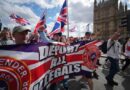 Des manifestants marchent avec une banderole anti-immigration.