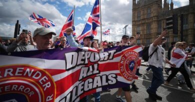 Des manifestants marchent avec une banderole anti-immigration.