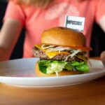 Deux adolescents testent un burger végétarien dans un comparatif de fast-foods.