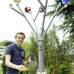 Un homme construit un arbre à vent pour recharger son portable en milieu urbain.