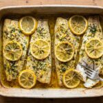 Lieu noir cuit au four avec herbes et citron : une méthode de préparation appréciée dans la gastronomie.