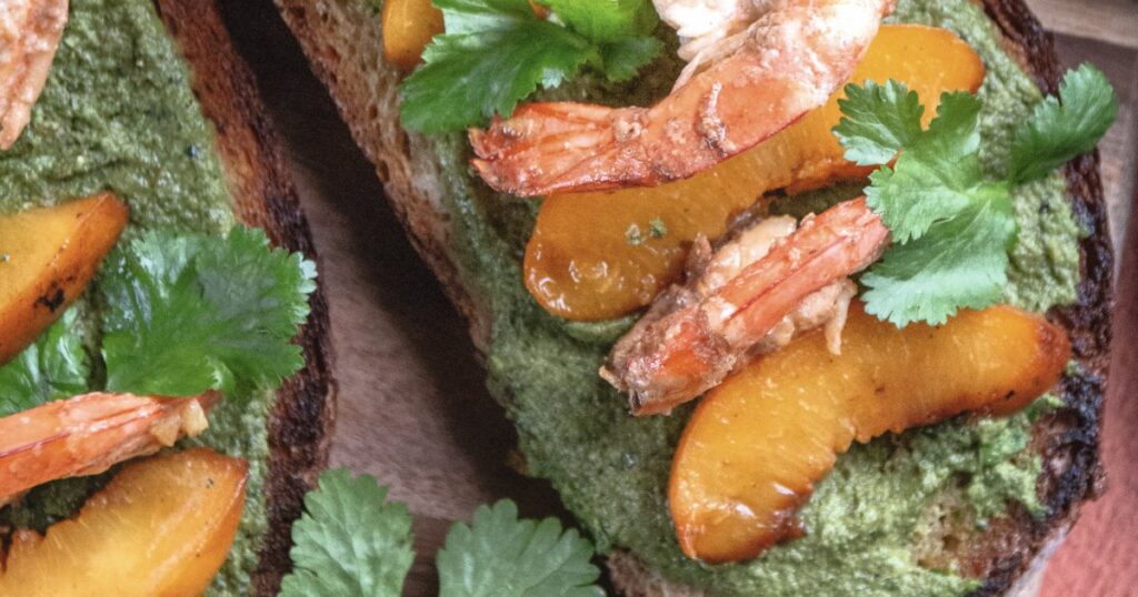 Bruschettas aux crevettes et pêches grillées : une recette estivale à découvrir en cuisine.