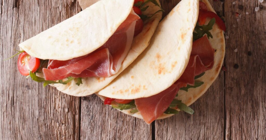 Recette traditionnelle de piadina italienne au jambon, fromage et légumes à découvrir