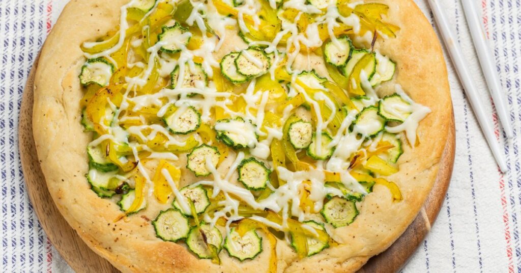 Recette de pizza blanche aux courgettes et mozzarella avec huile au basilic.