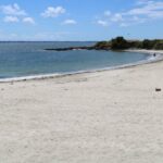 Une femme décède sur une plage près de Lorient, enquête ouverte par les autorités locales.