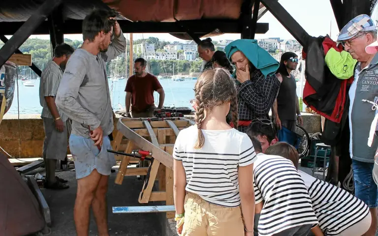 Aux Fêtes maritimes de Douarnenez, des enfants apprennent la construction de bateaux.