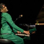 Jon Batiste fusionne Mozart et Monk pour redéfinir le jazz contemporain.
