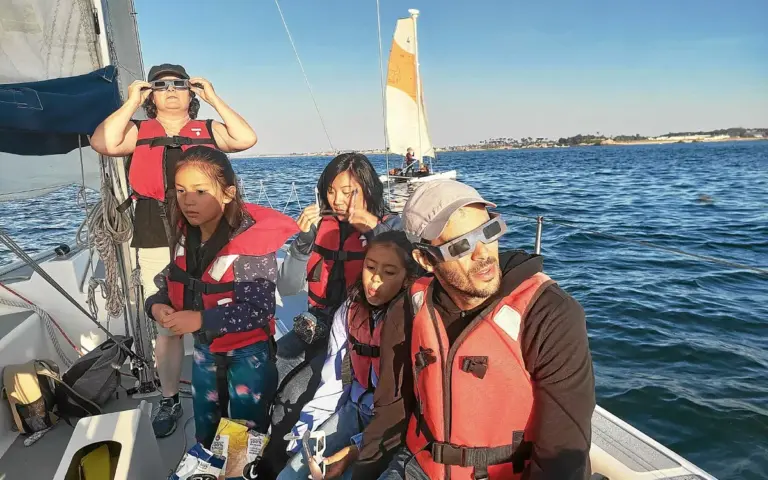 Des passionnés observent l’éclipse solaire partielle depuis un voilier près de Roscoff.