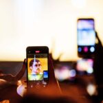 Des spectateurs se filment en concert, détournant l&rsquo;attention de l&rsquo;artiste.