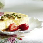 Recette de cheesecake à la ricotta, pistaches, miel et fraises pour une dégustation estivale.