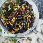 Moules au beurre d’ail et pommes de terre sautées : une spécialité culinaire française appréciée.