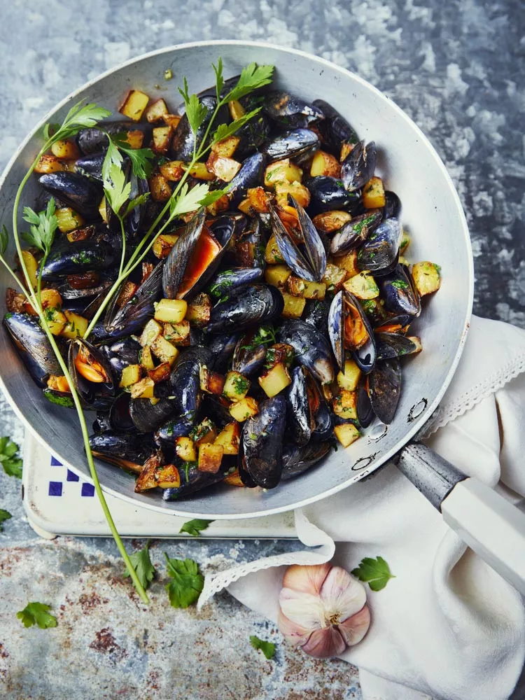 Moules au beurre d’ail et pommes de terre sautées : une spécialité culinaire française appréciée.
