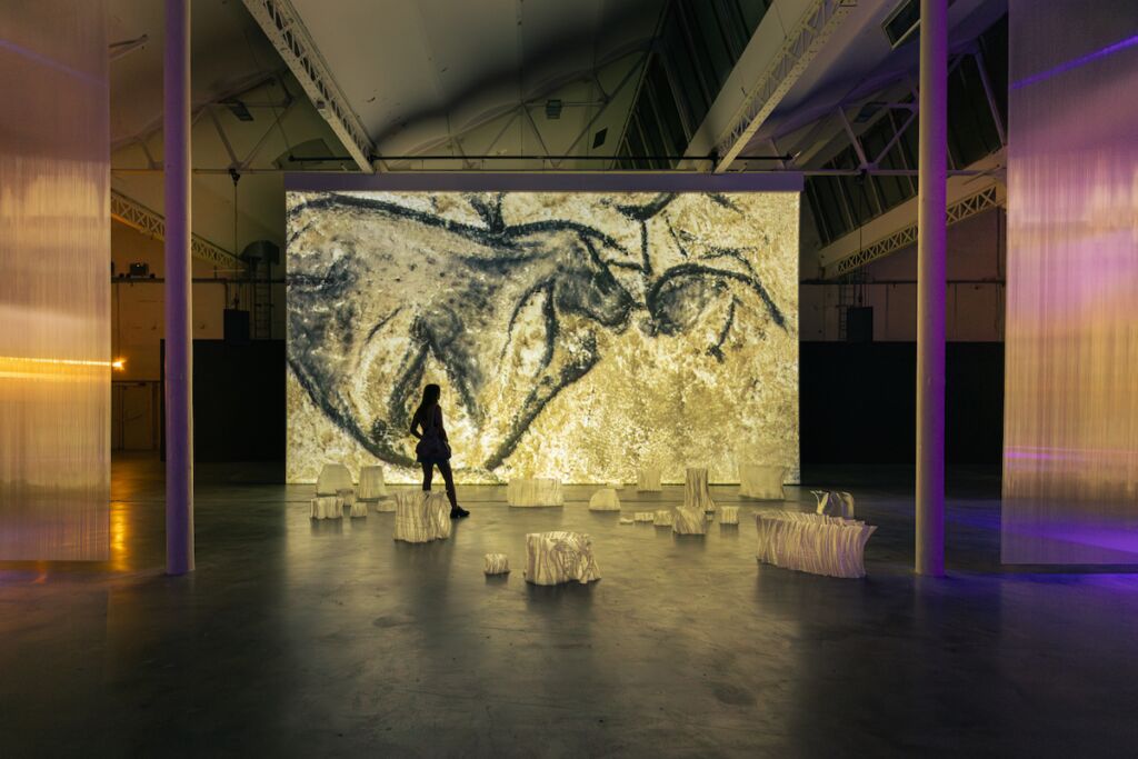 Justine Emard expose son œuvre « Rêves Premiers » au sein d’une galerie d’art contemporaine.